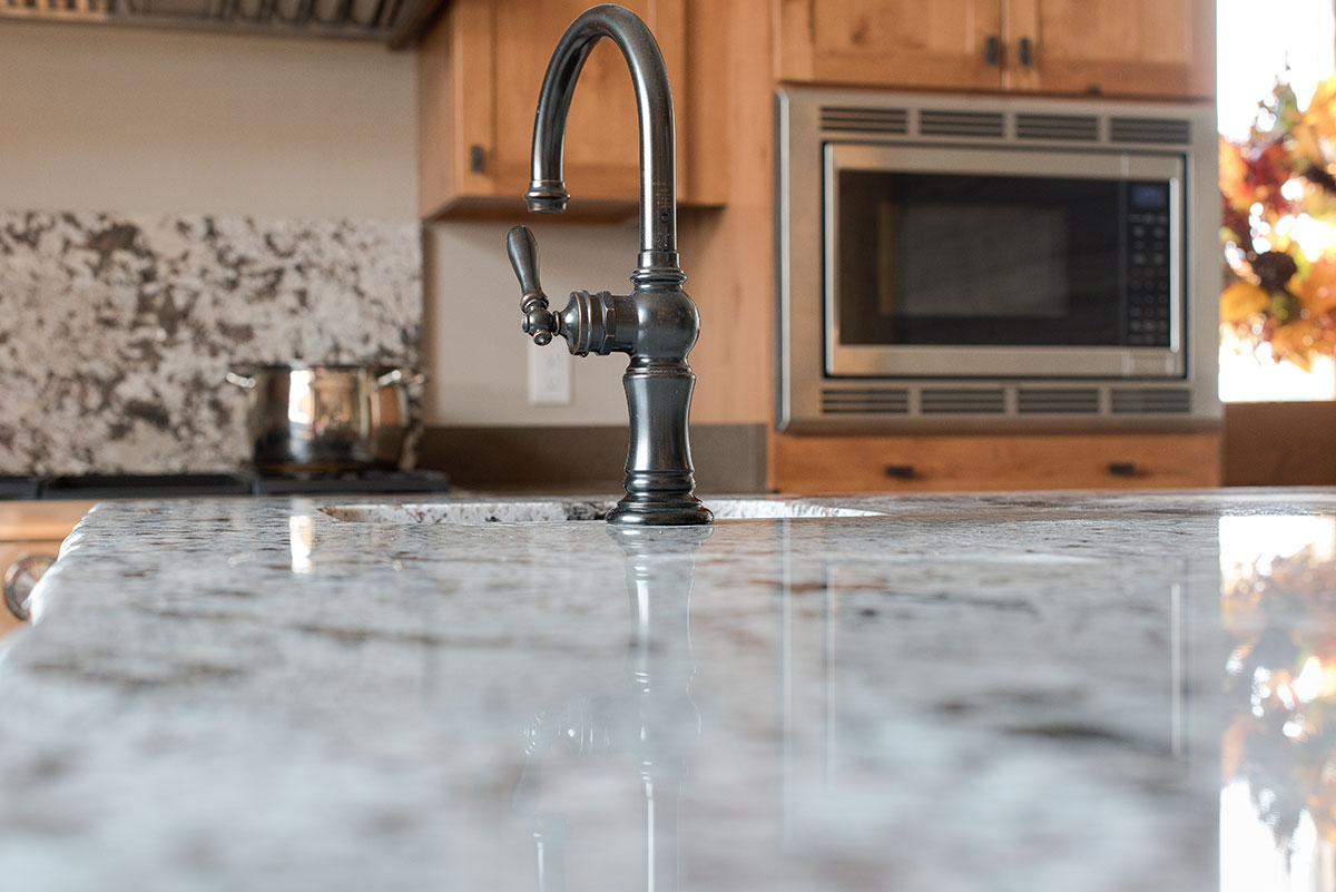 View at countertop height of a bronze rubbed faucet for an extra prep sink on kitchen island